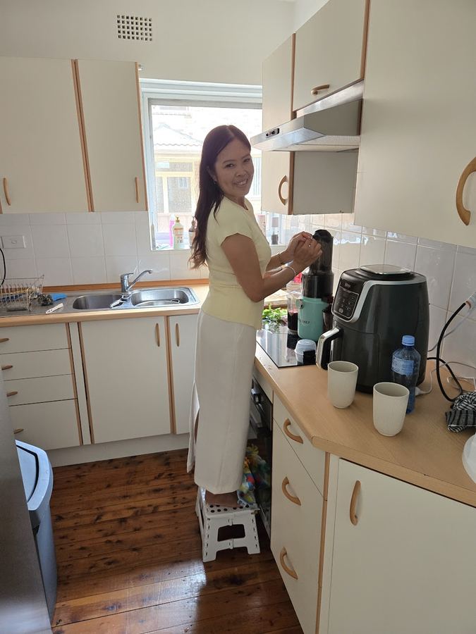Chantelle smiling while making juice in the kitchen